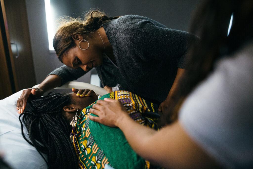 A doula comforts someone in labor.