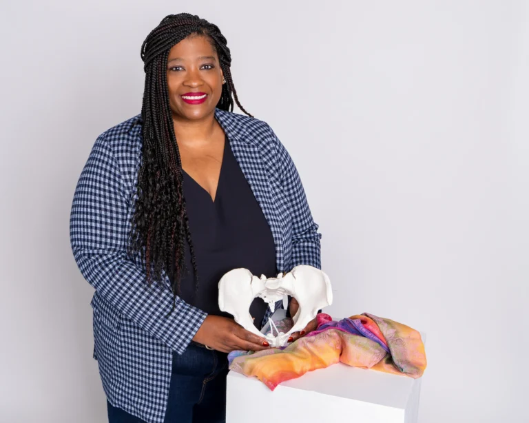 TaKiesha Smith is one of the instructors who works with lactation in the doula training. Here she stands with her pelvis and doula tools.