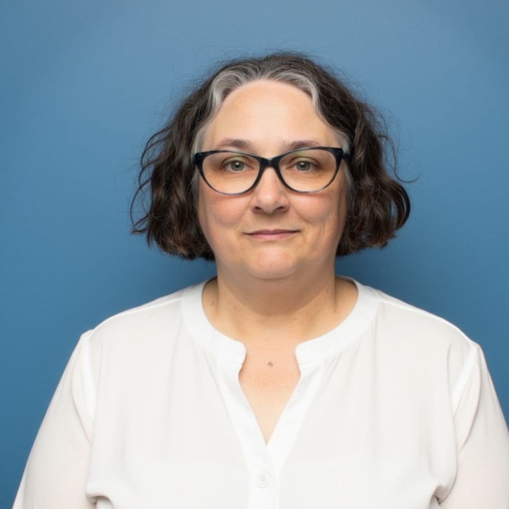 Robin Elise Weiss Birth Doula Trainer in a white shirt on a bue background.